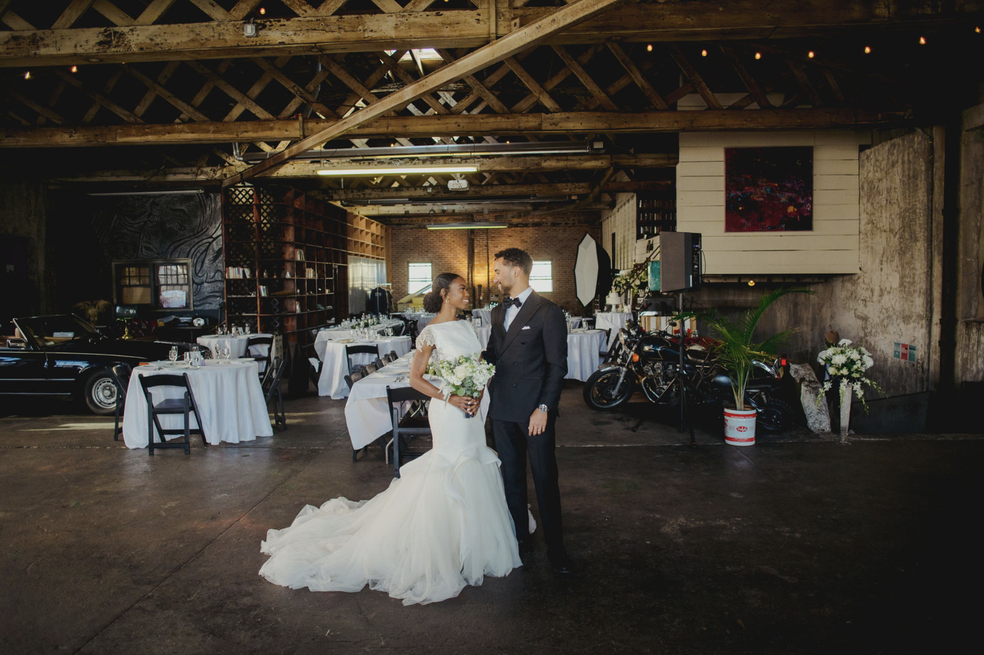 Couple posing in front of tables at ODR Studios wedding venue Newark NJ